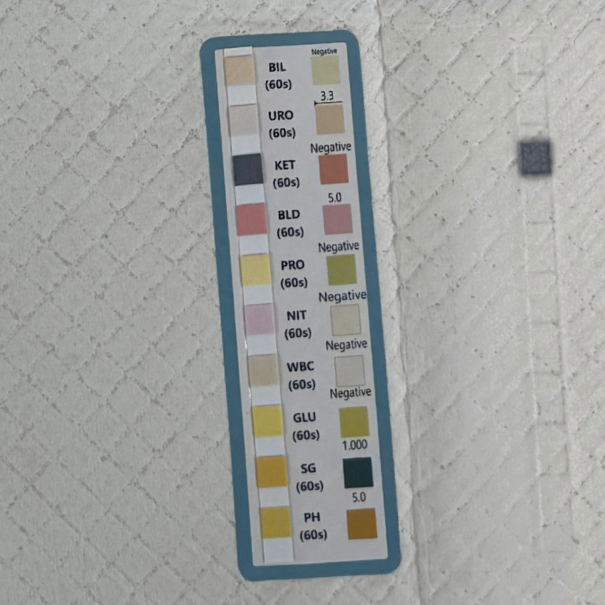 Close-up van de teststrip op de Medpad met de tien velden BIL, URO, KET, BLD, PRO, NIT, WBC, GLU, SG en PH